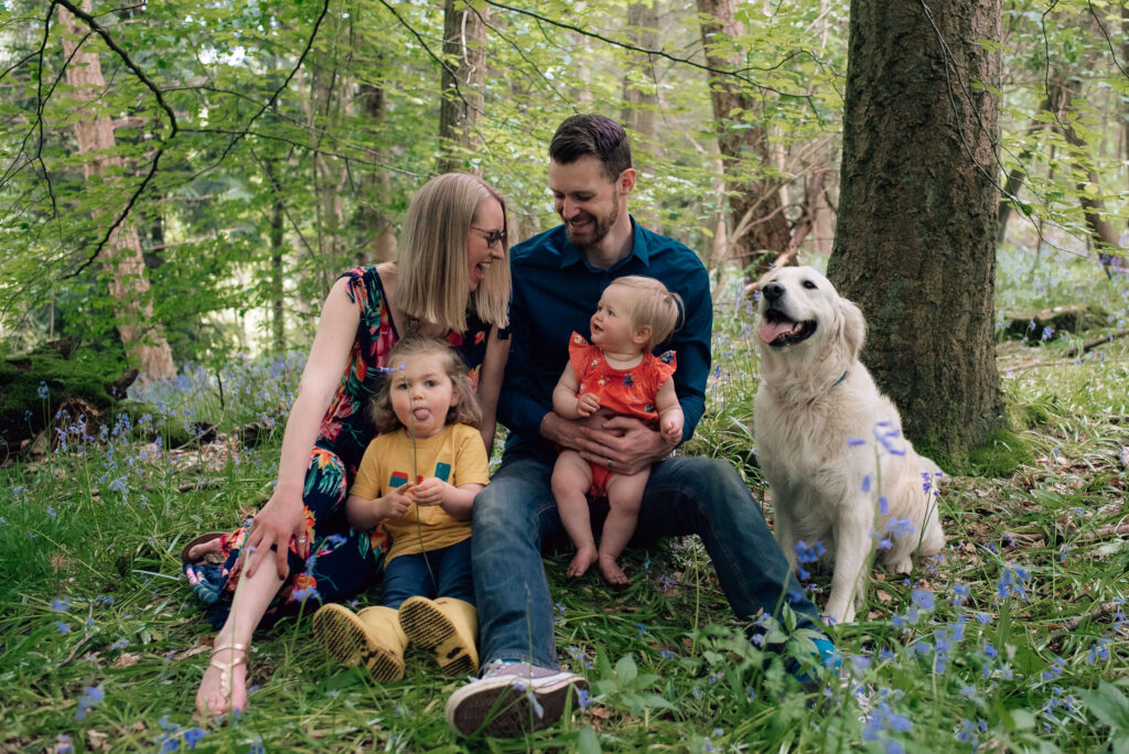 relaxed family photography glasgow family in the woods laughing with kids and dog in the bluebells
