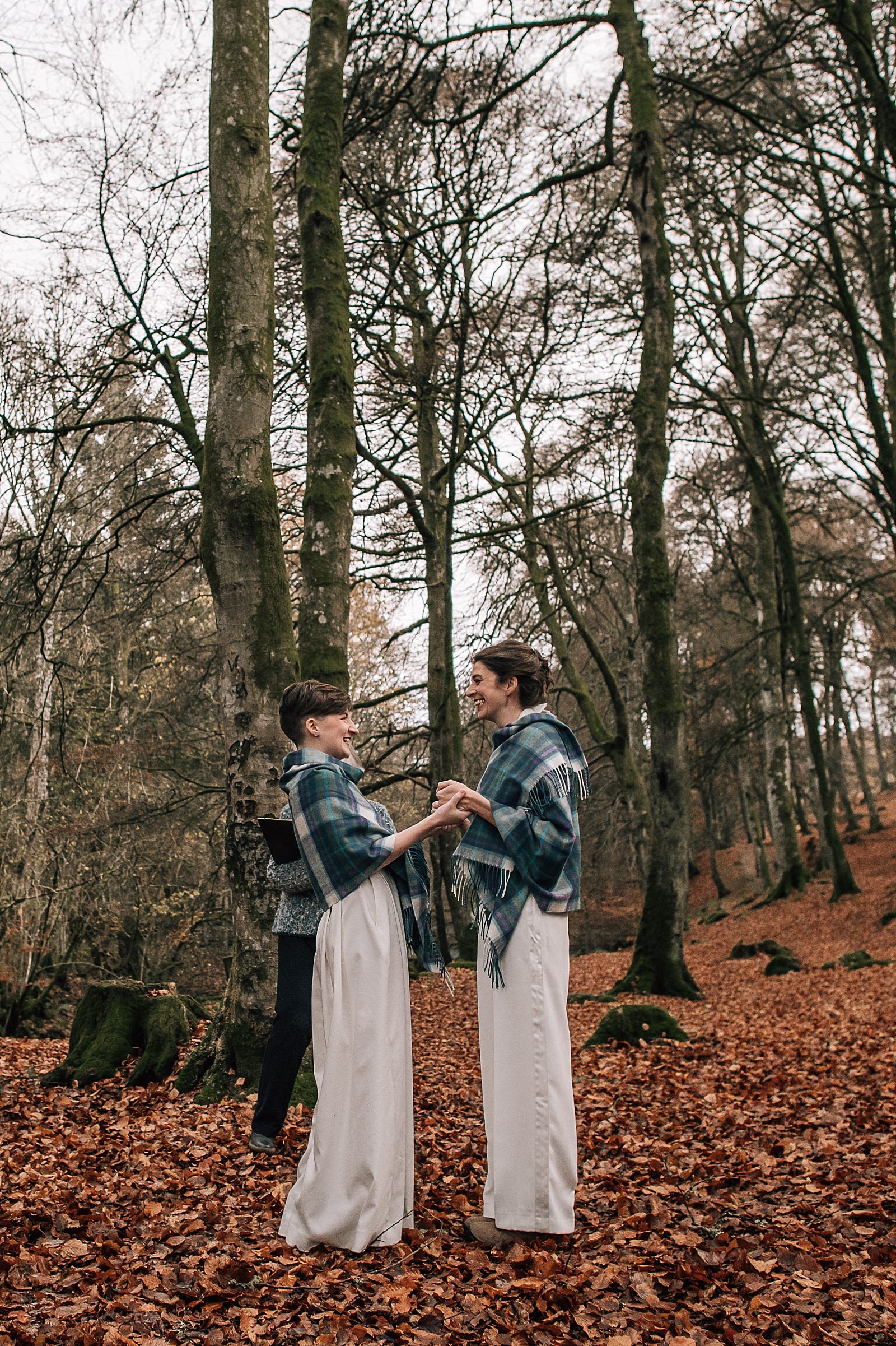 two brides smiling and laughing at their outdoor ceremony in the woods at their boreland loch tay wedding