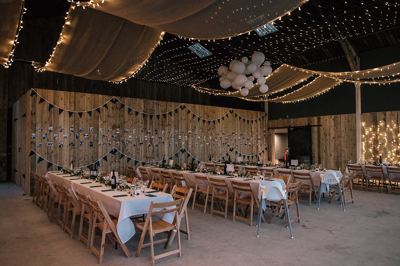 interior of boreland loch tay wedding venue set up for reception dinner wedding event with wooden tables and chairs and fairy lights