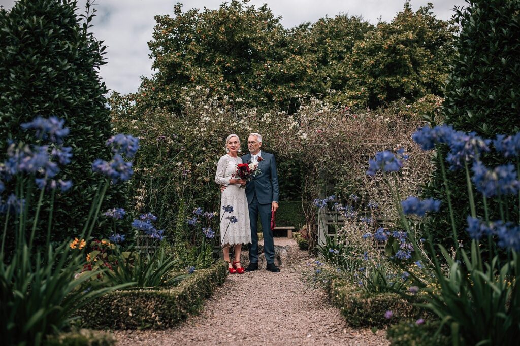 bride and groom pose for photos in gardens in edinburgh city centre on their elopement in scotland