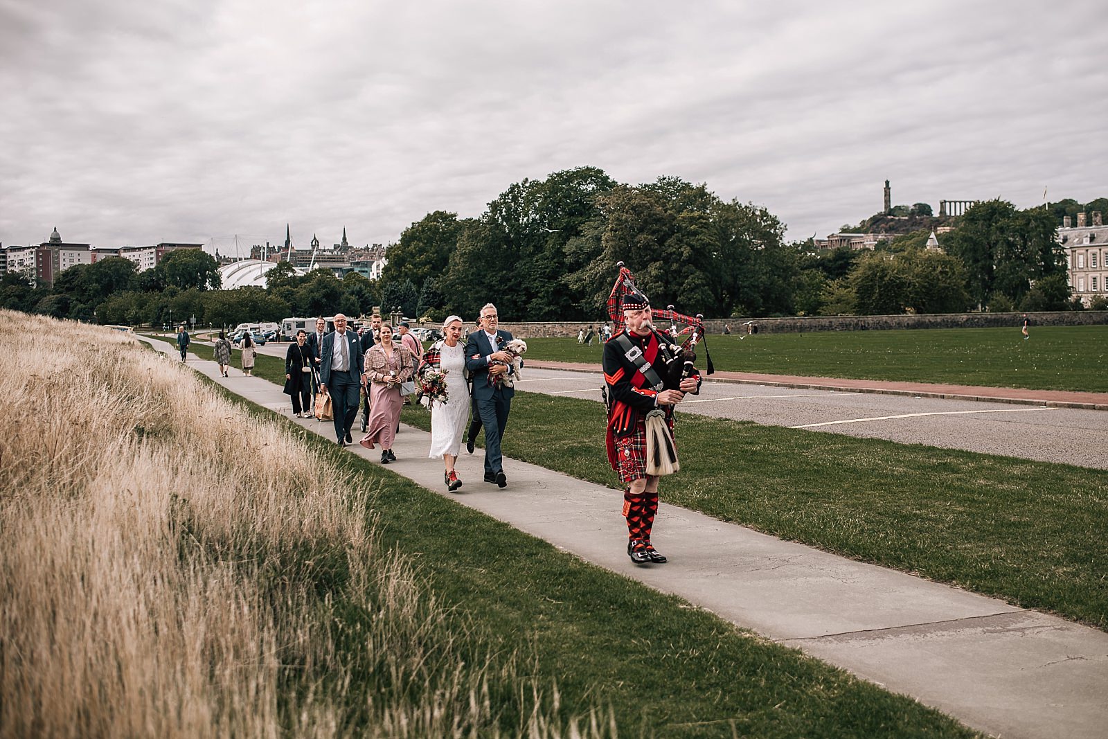 piper leads wedding party to arthurs seat for elopement wedding outdoors in edinburgh city centre scotland