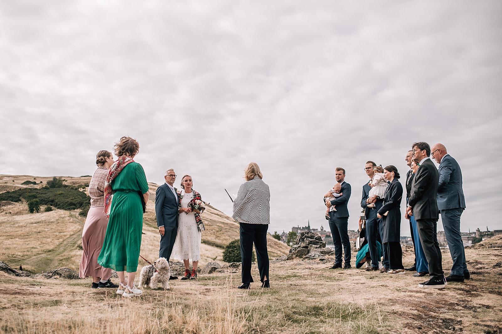 elopement photographer edinburgh captures outdoor wedding ceremony on arthurs seat scotland with small group of guests