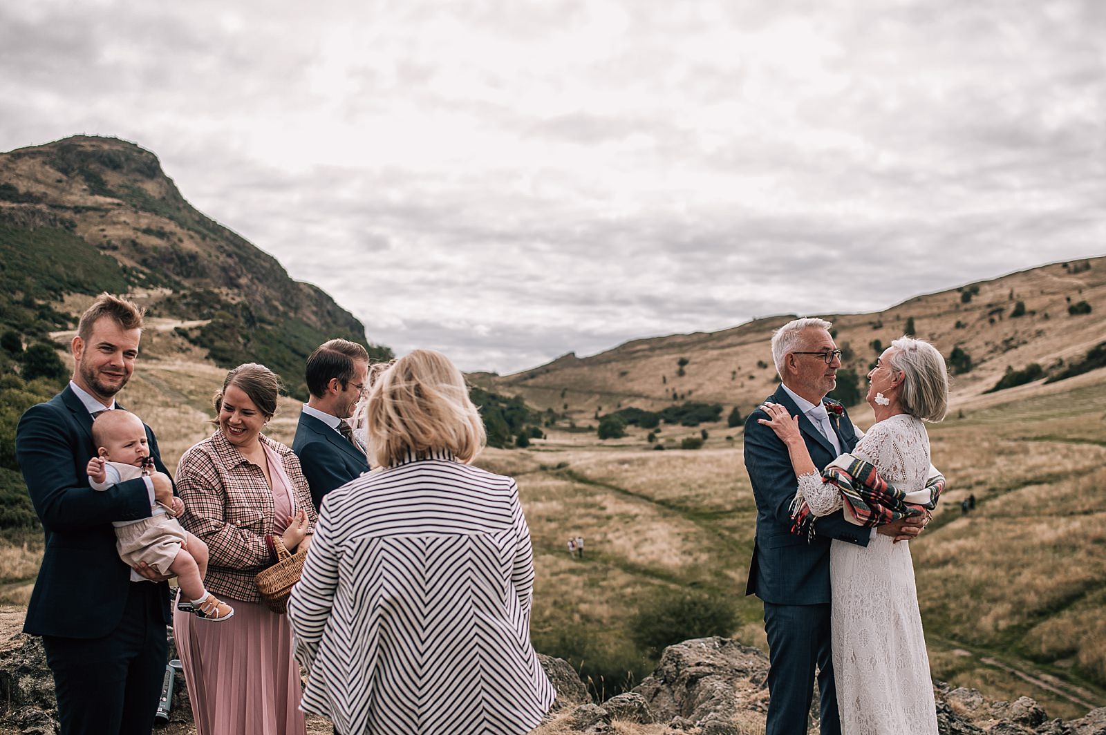 elopement photographer edinburgh captures outdoor wedding ceremony on arthurs seat scotland with small group of guests