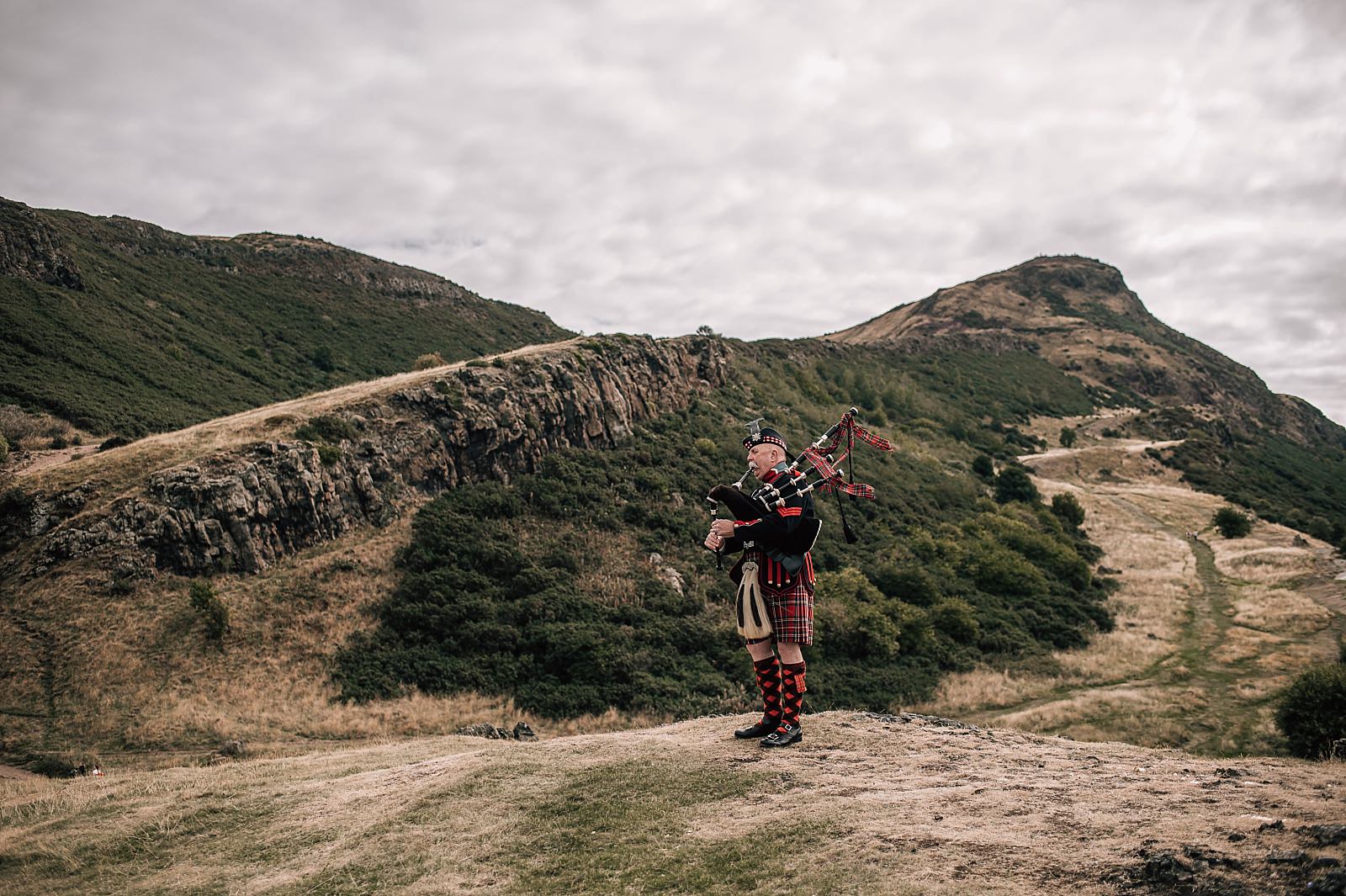 piper piping on arthurs seat for elopement wedding outdoors in edinburgh city centre scotland
