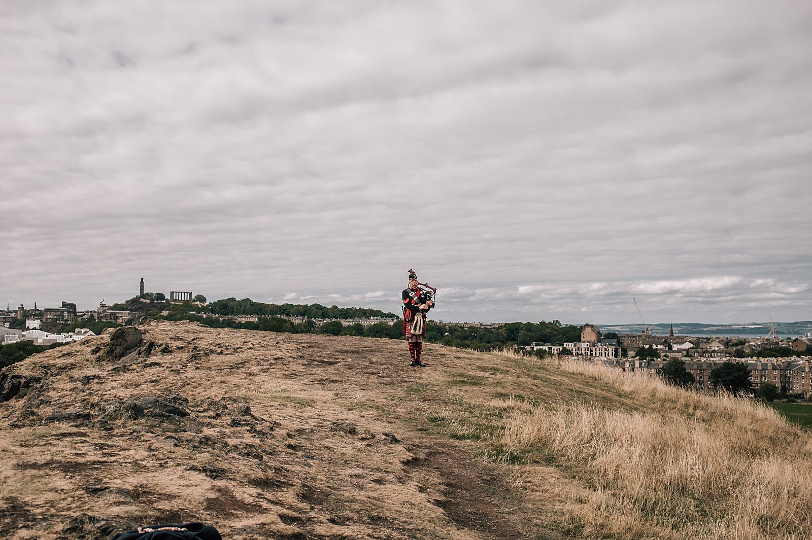 scottish piper on arturs seat for small elopement wedding day edinburgh