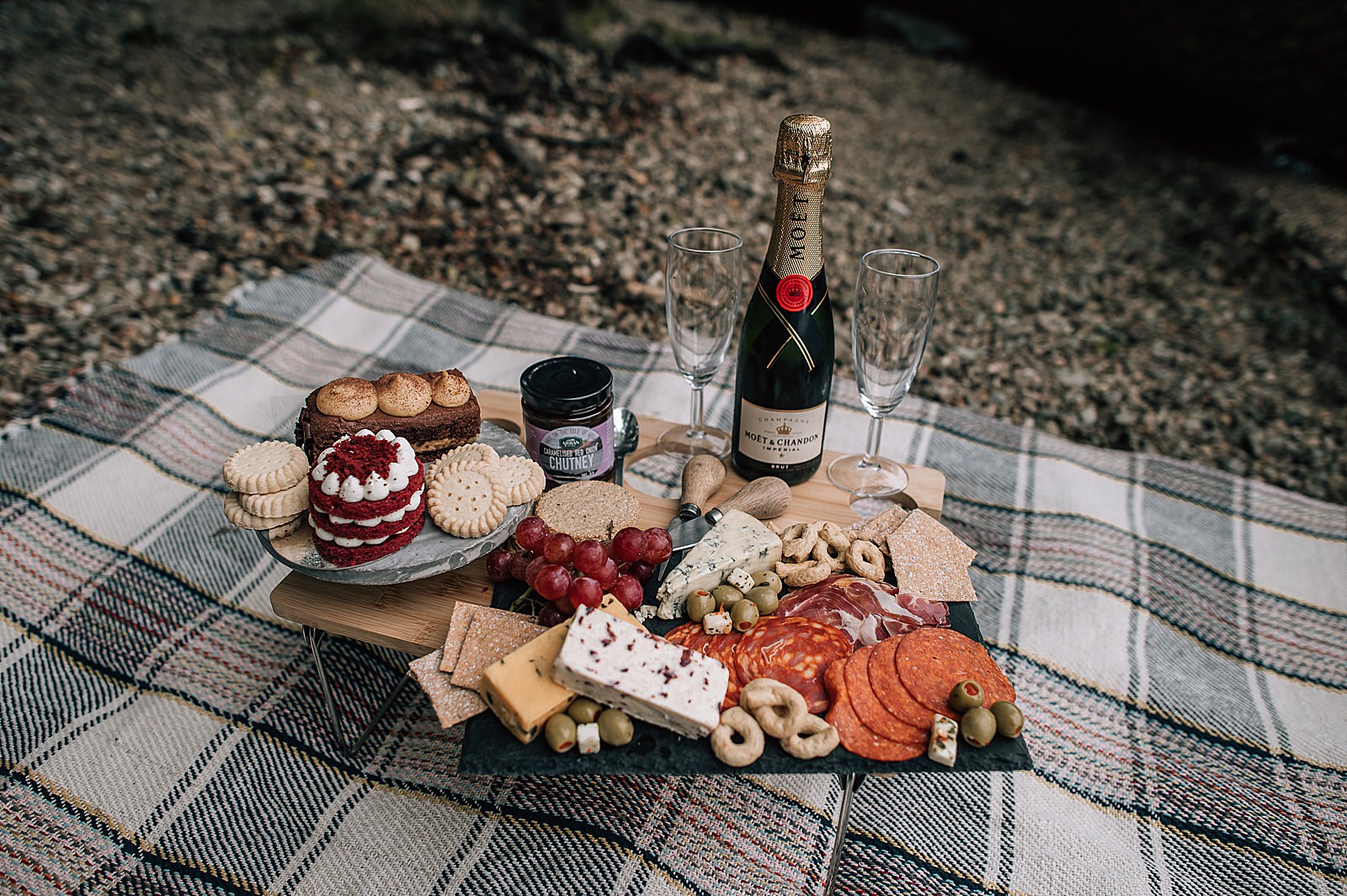 luxury picnic with cheeseboard, cakes and champagne for surprise proposal on shores of Loch Lomond