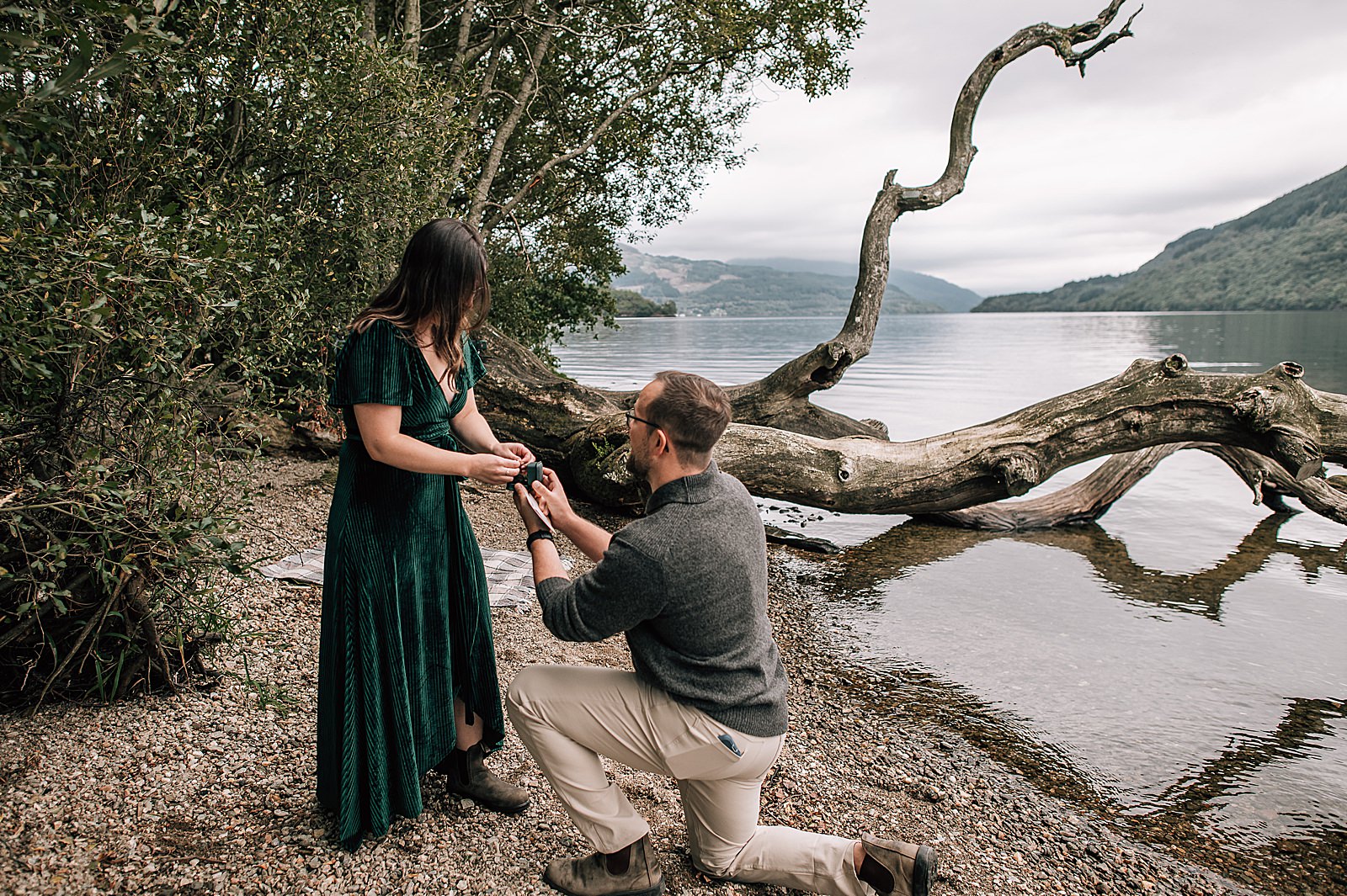 a surprise proposal glasgow location near the city at firkin point on Loch Lomond showing a couple during a surprise proposal on the shore by proposal photographer scotland