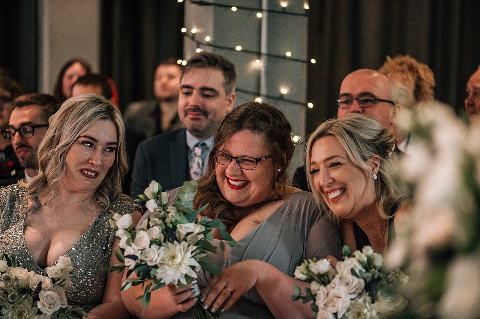 bridesmaids laughing and smiling dressed in grey bridesmaid dresses at west brewery wedding for a unique wedding glasgow scotland