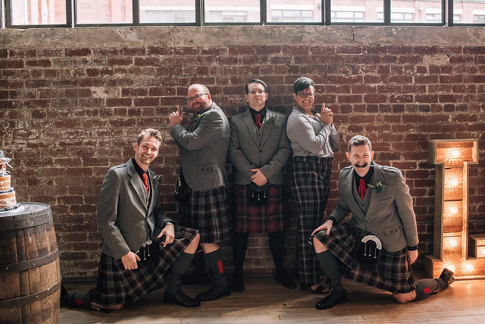 groom with groomsmen and groomswoman doing silly Charlie's angels pose at informal glasgow wedding at west brewery