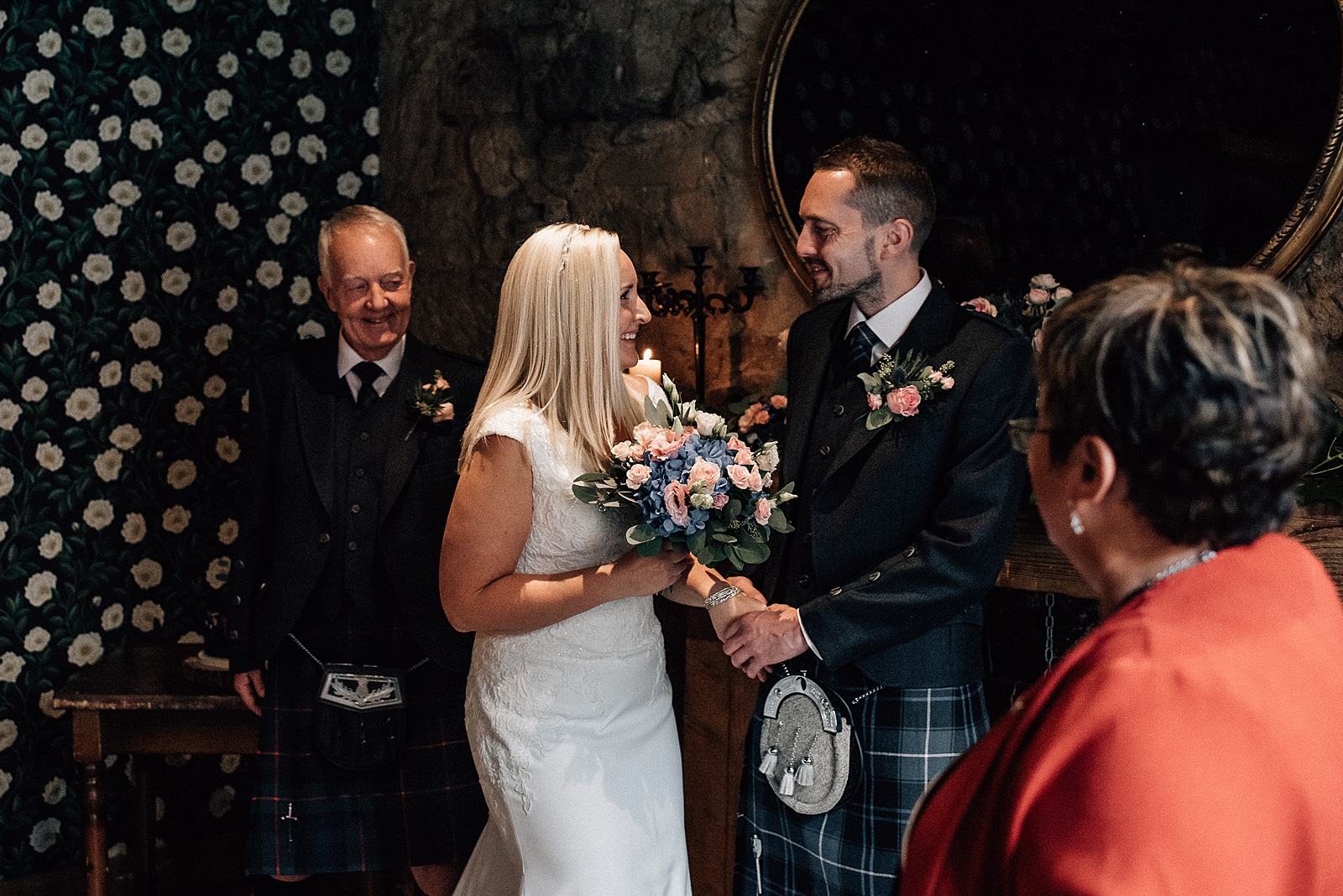 bride in white v neck dress holding pink and blue bouquet as she sees her groom for the first time before their ceremony at the bothy glasgow wedding