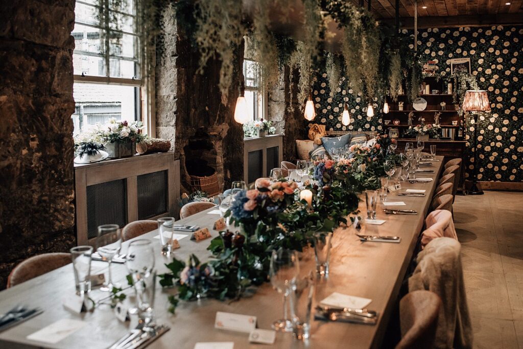 the bothy glasgow wedding set up for ceremony in the scullery with flowers, foliage chandelier and decorative pendant lighting