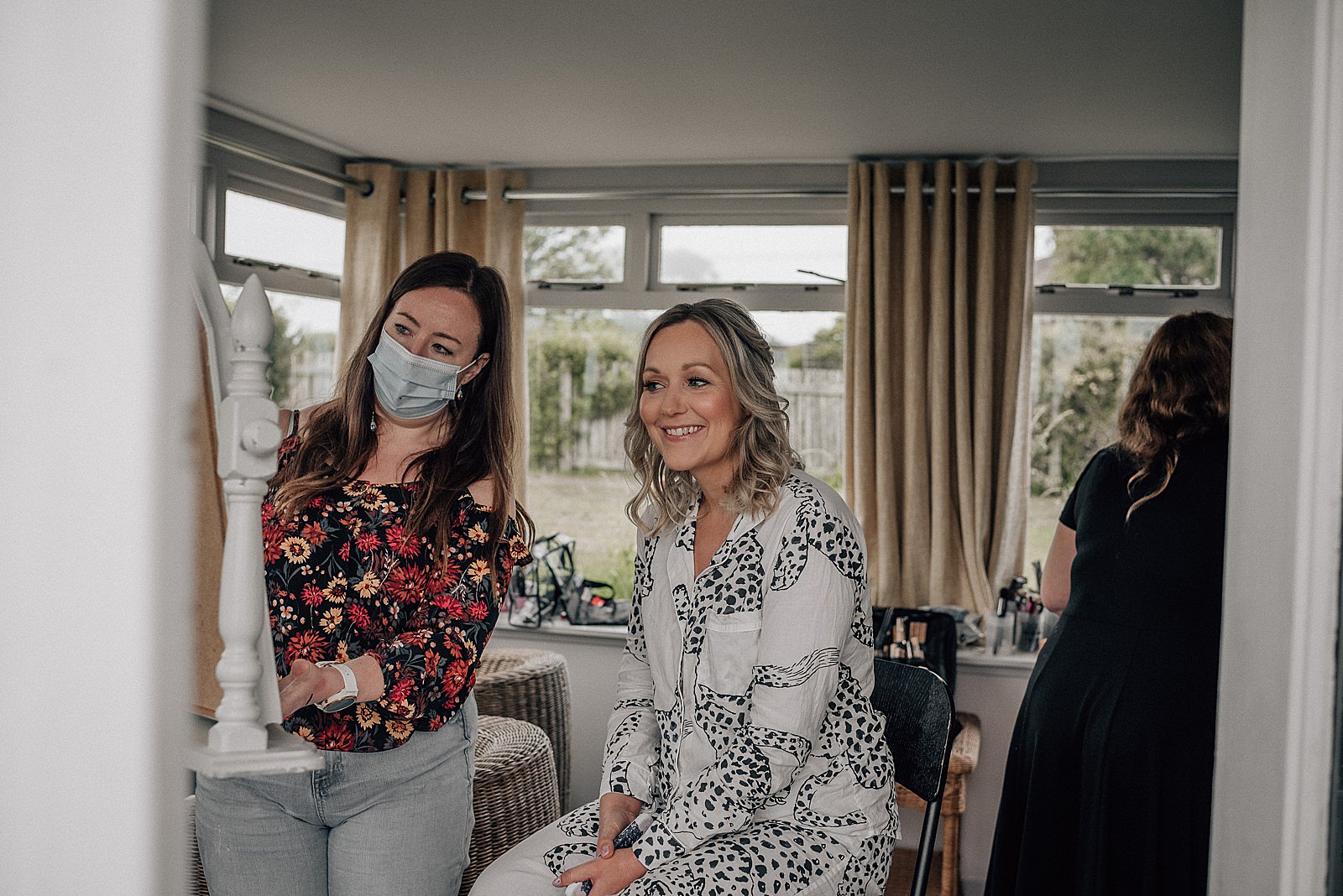 bride smiling in the mirror while having her makeup done on her wedding morning at the cow shed scotland for her diy Scottish wedding