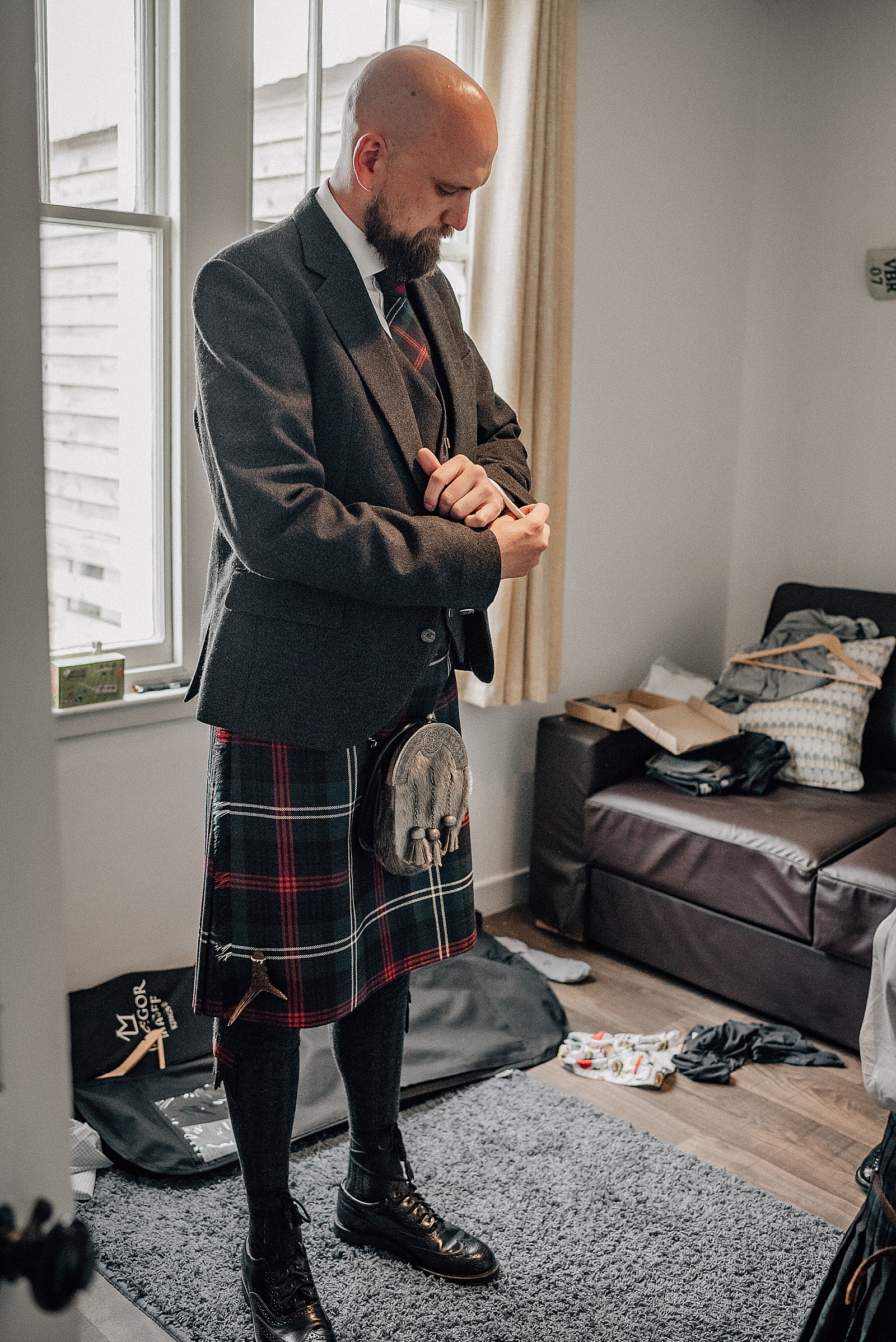 groom getting ready during wedding morning in bridal party accommodation near the cow shed scotland in crail