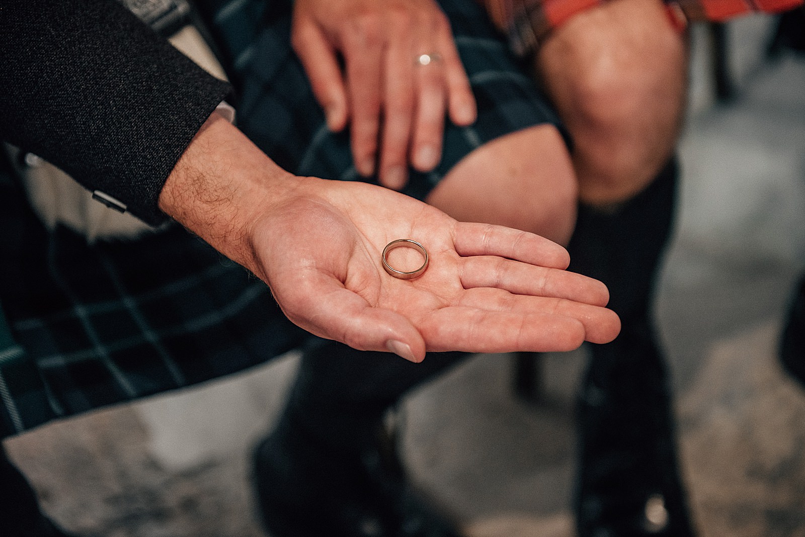 a close up shot of best man's hand holding groom's ring during a diy wedding at the cow shed scotland