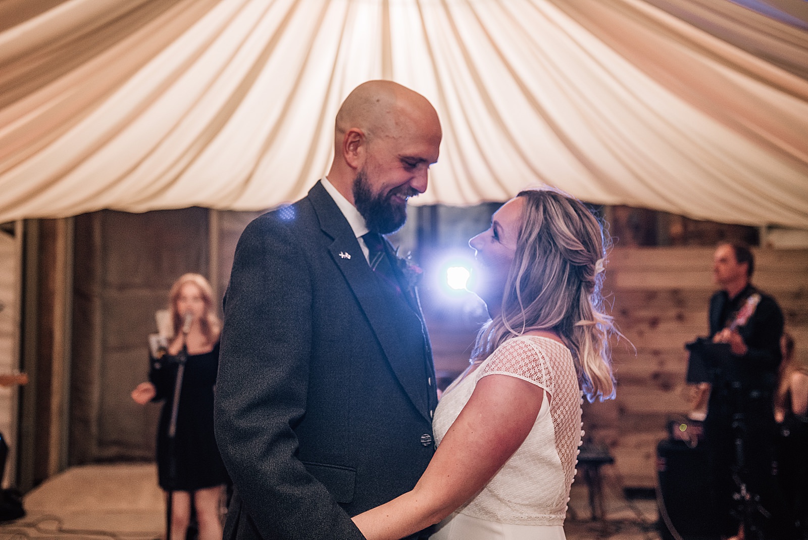 bride and groom smiling and looking at each other as they dance at their diy Scottish wedding at the cow shed scotland