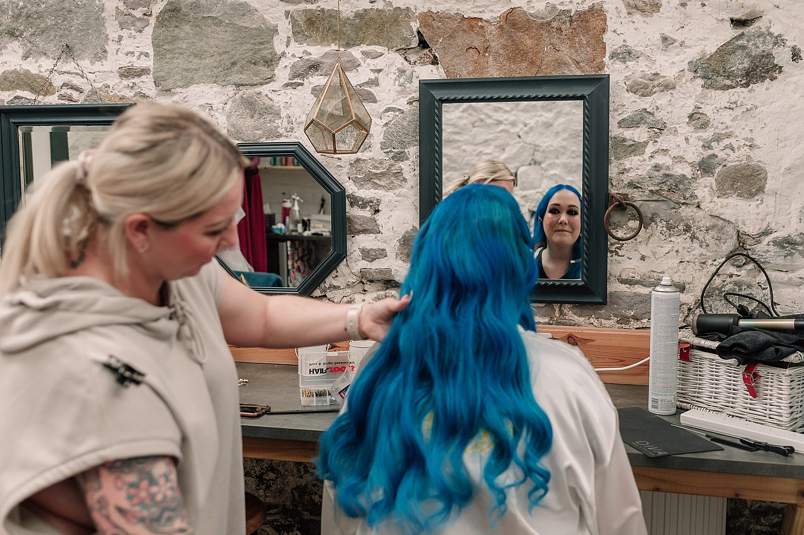 bride with blue hair getting ready and looking in the mirror on the morning of her comrie croft wedding