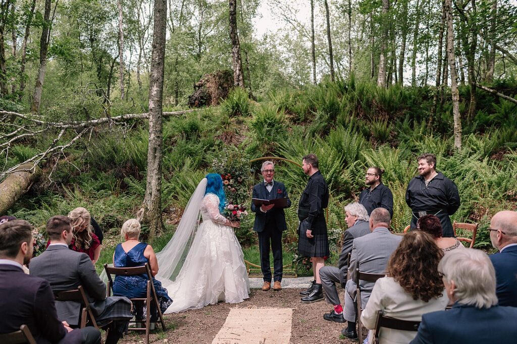 bride and groom during their Scottish woodland wedding ceremony outdoors at comrie croft one of the best Scottish barn wedding venues in scotland