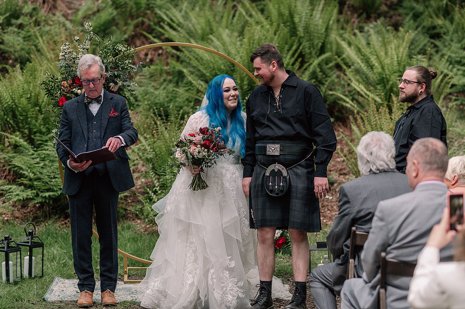 bride and groom smiling during their Scottish woodland wedding ceremony at comrie croft scotland a unique Scottish wedding venue