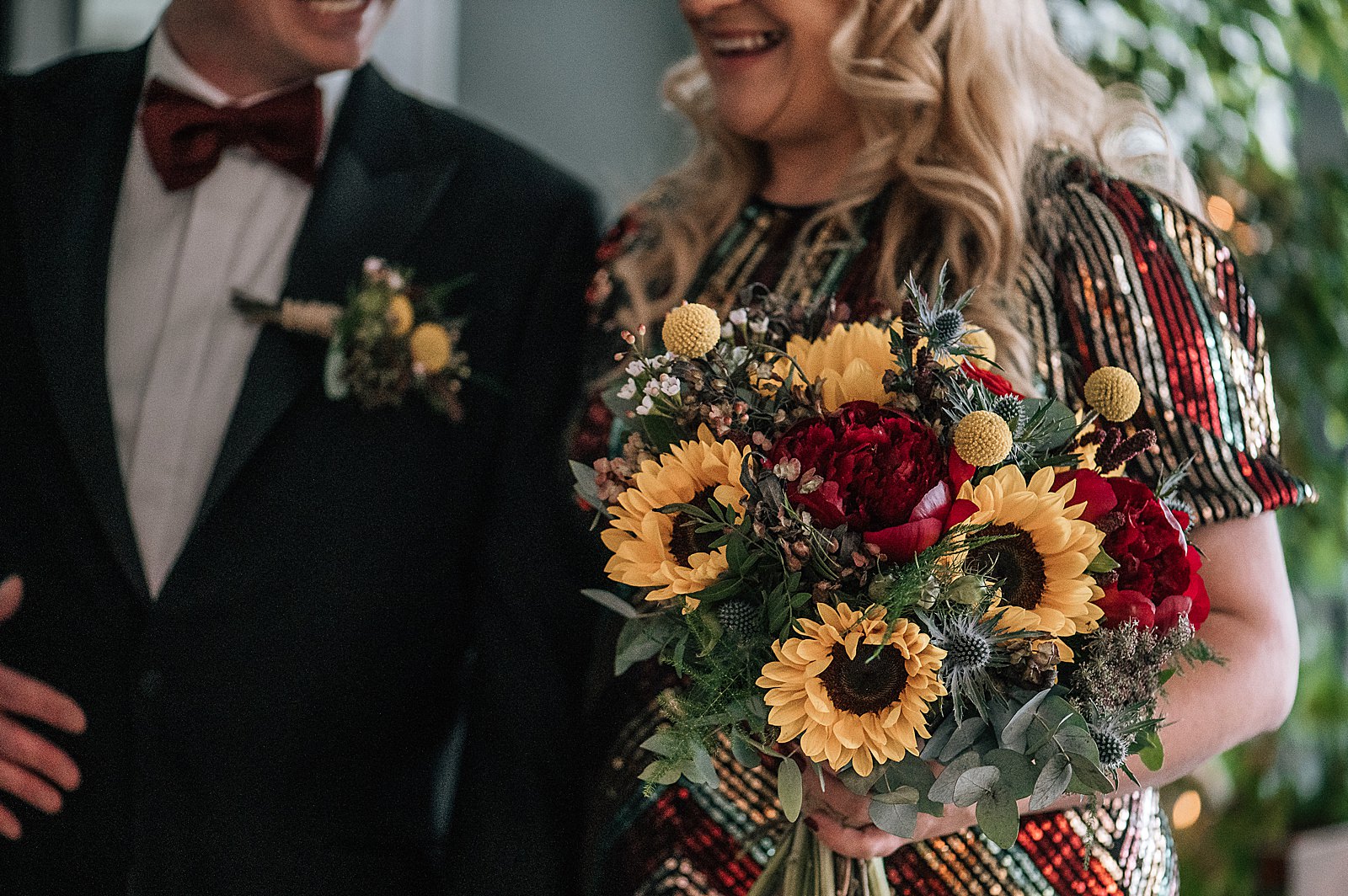 bride smiling in sequin wedding dress with sunflower bouquet