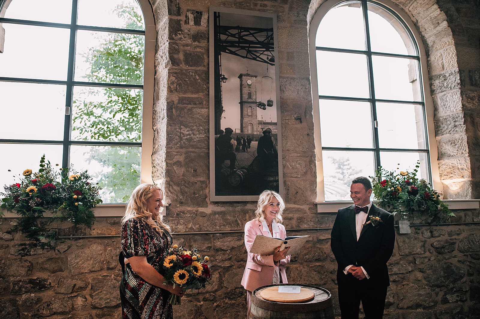 bride and groom standing with celebrant during ceremony at their distillery wedding scotland at clydeside distillery