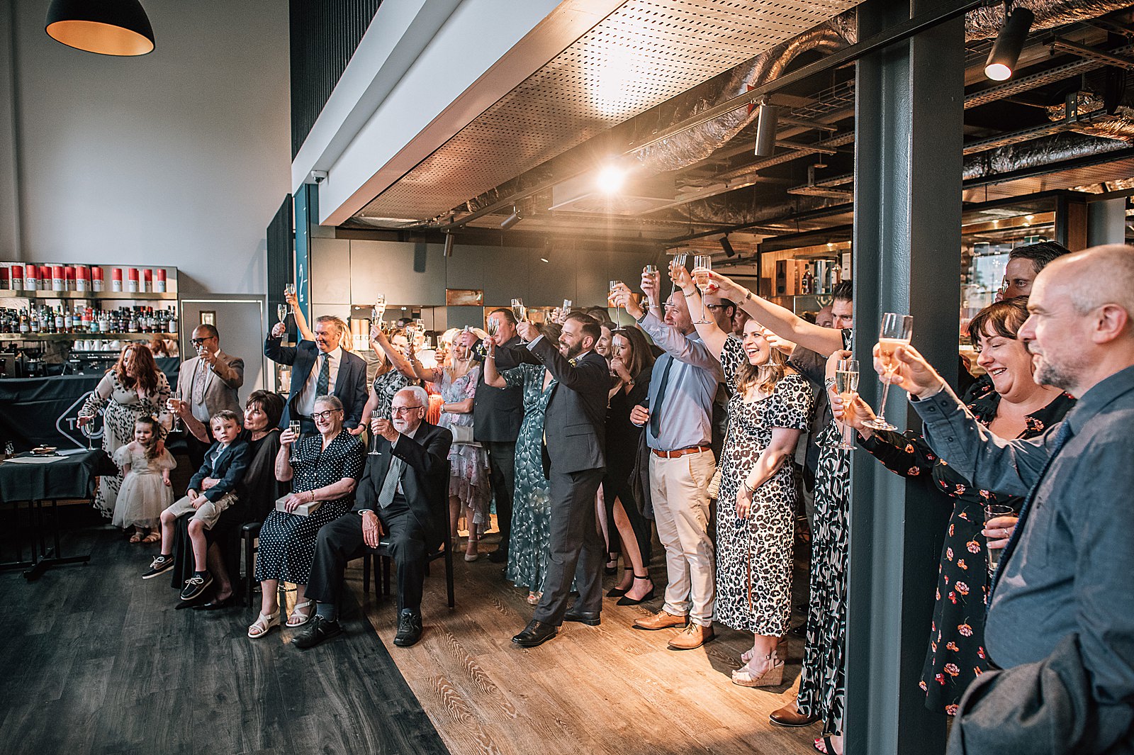 wedding guests cheers to bride in groom inside clydeside distillery wedding ceremony