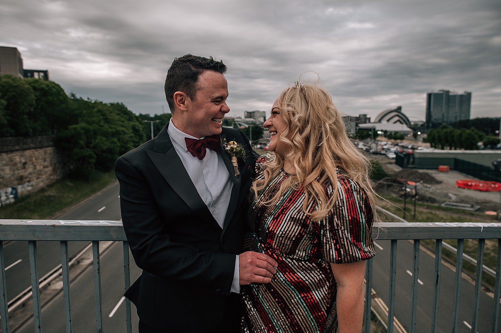 bride and groom standing on bridge and smiling at each other for glasgow wedding photographer portrait