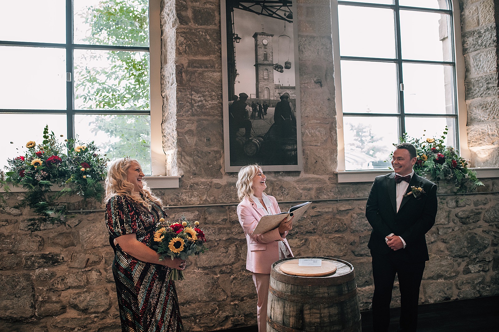 bride and groom laughing with celebrant at their distillery wedding scotland inside clydeside distillery