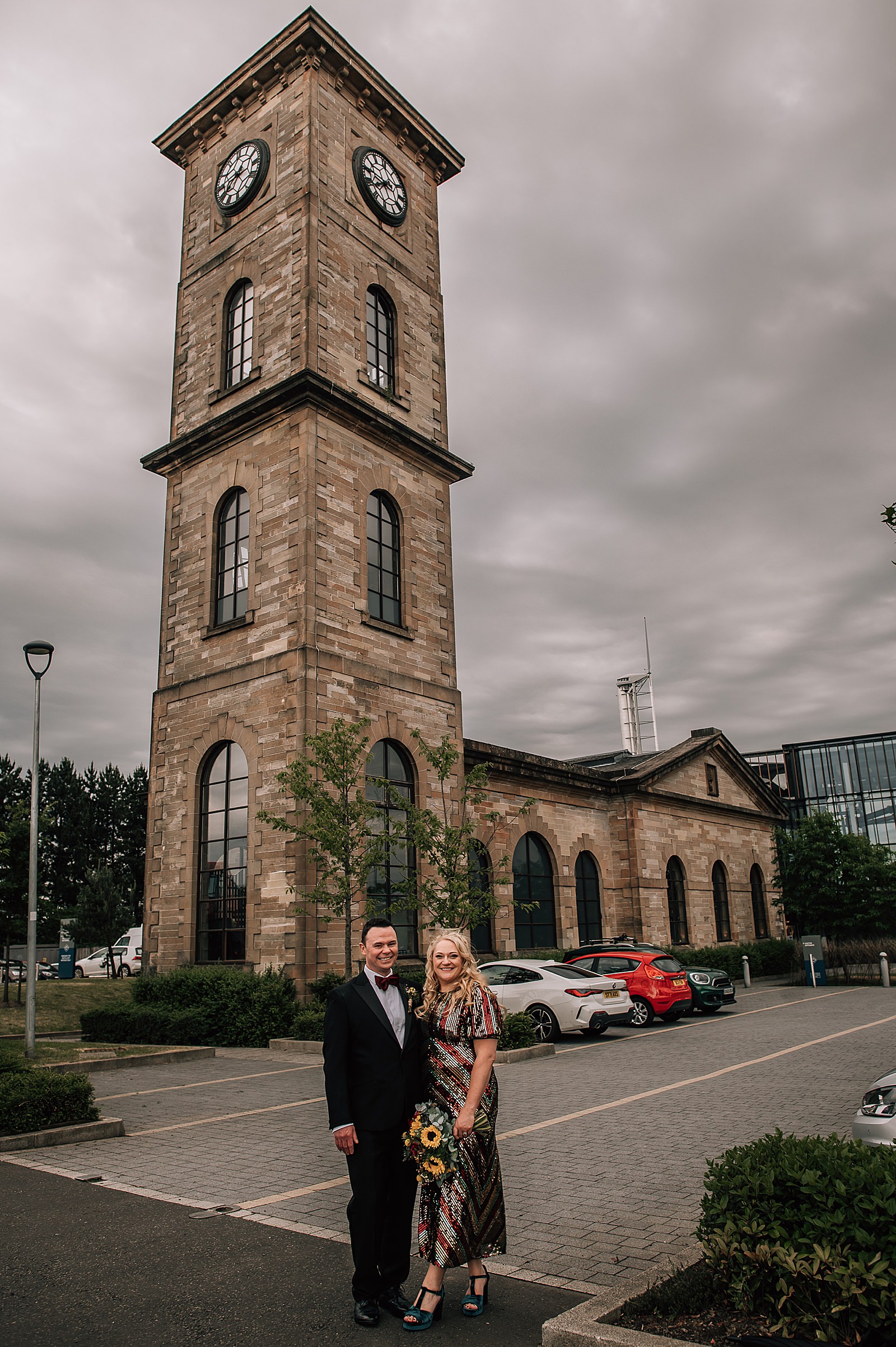 bride in sequin wedding dress standing with her groom outside in front of clydeside distillery for their distillery wedding scotland