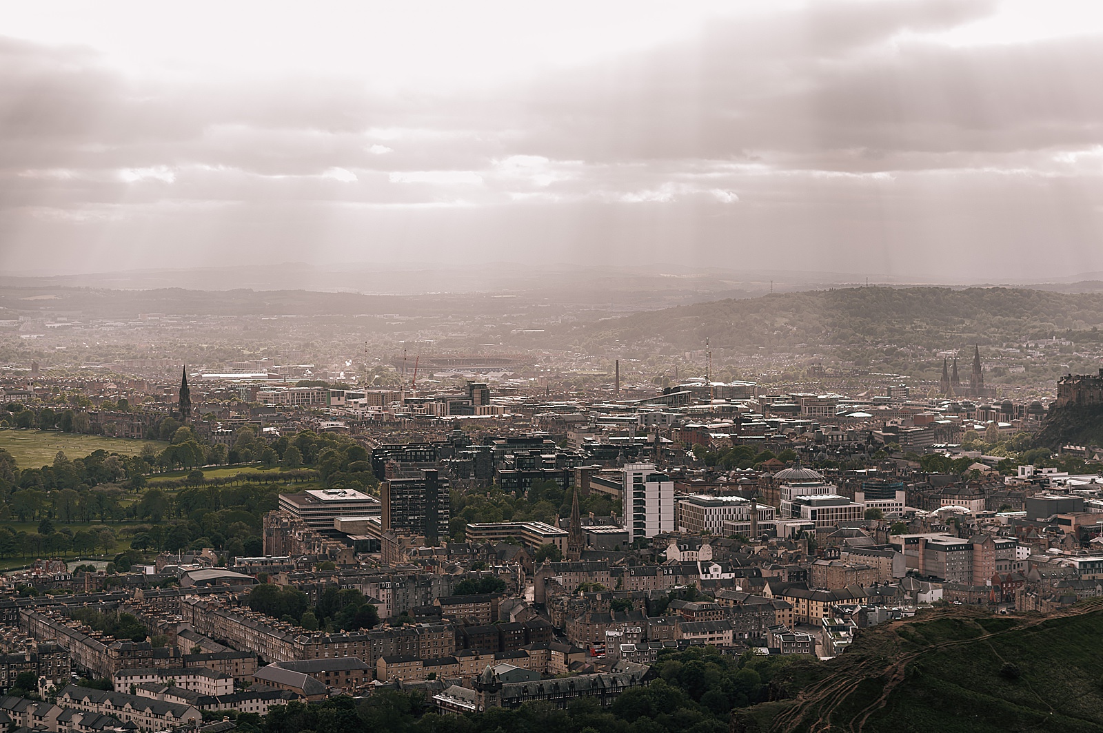 moody view with pockets of light over Edinburgh from Arthurs seat taken by Edinburgh proposal photographer