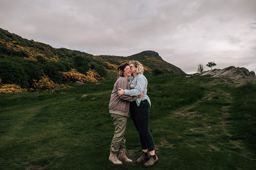 couple hugging and smiling after their lgbtq+ engagement photography shoot Edinburgh