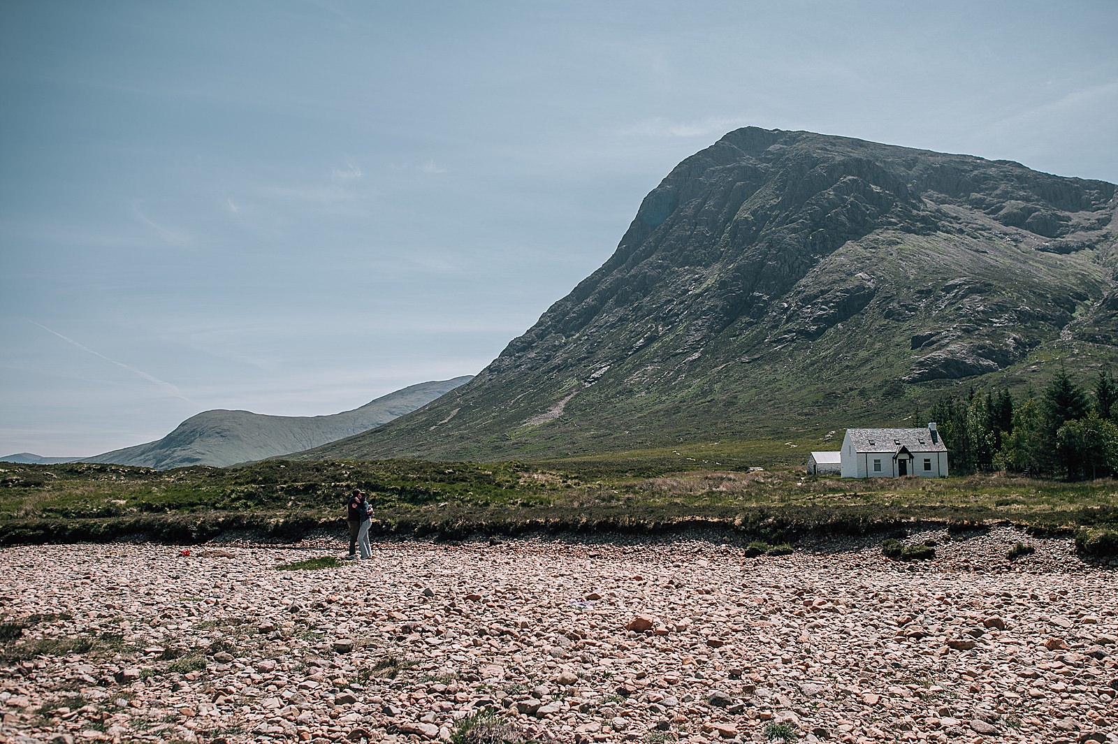 couple getting engaged in glencoe on a sunny day in front of Lagangarbh hut and buachaille etive mor captured by glencoe proposal photographer