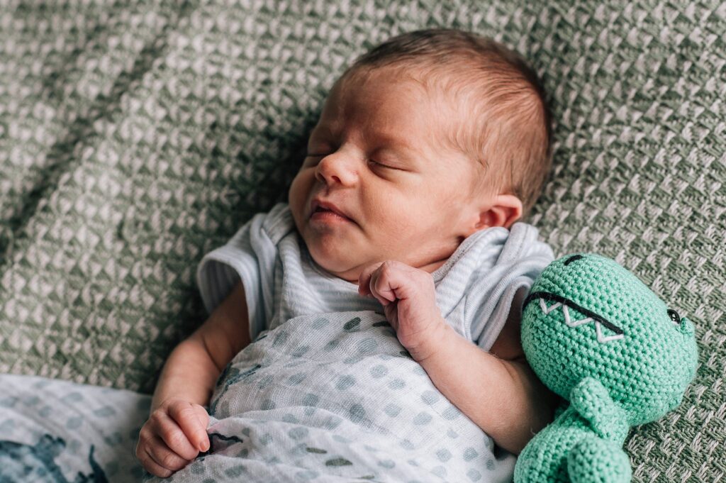 newborn baby sleeping with toy
