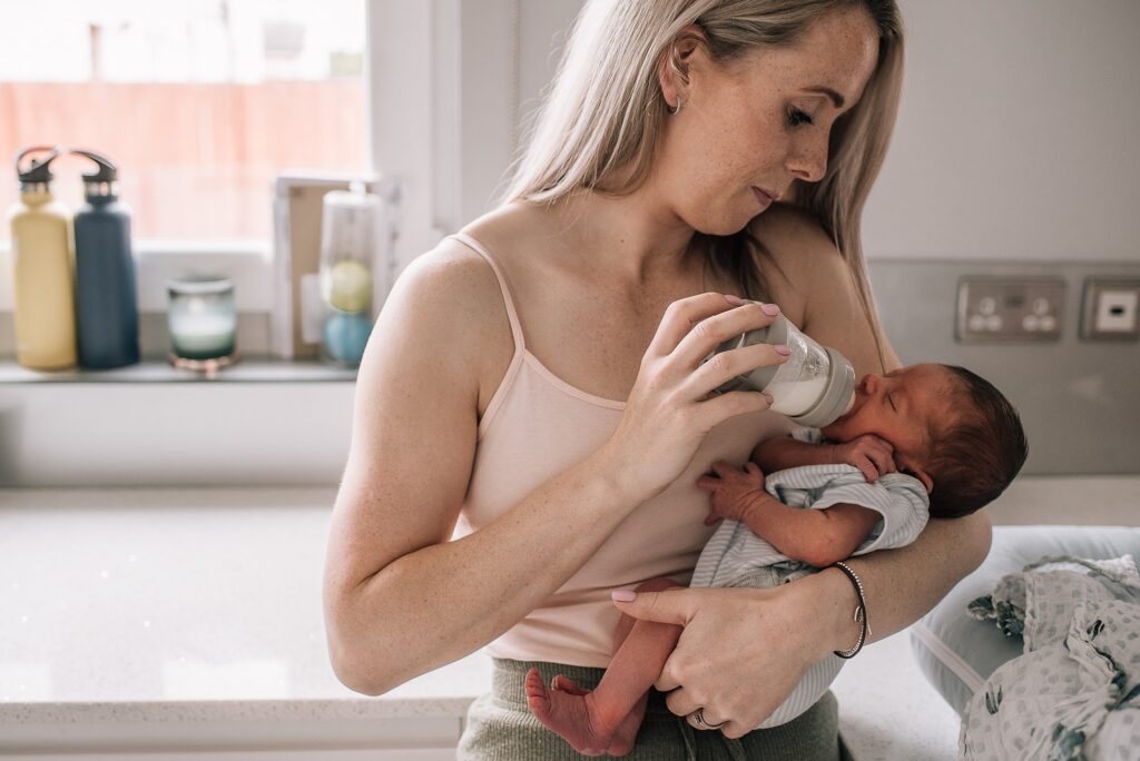woman feeding her newborn baby with a bottle of milk