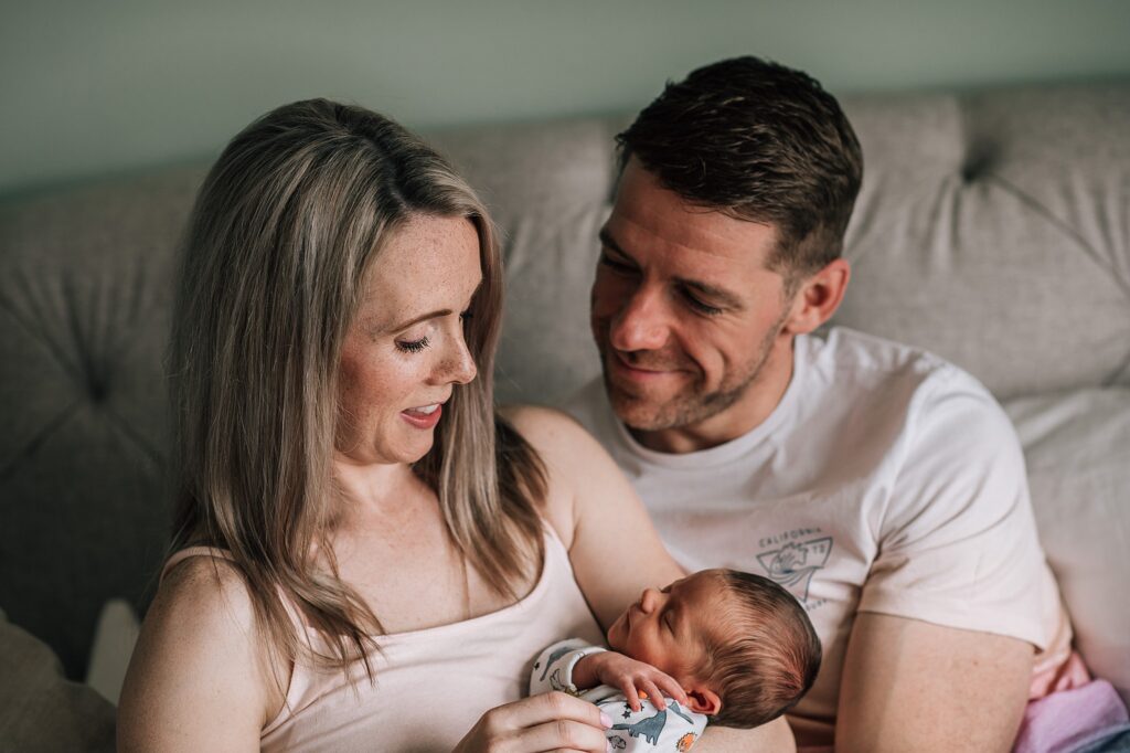 parents cuddling newborn baby together