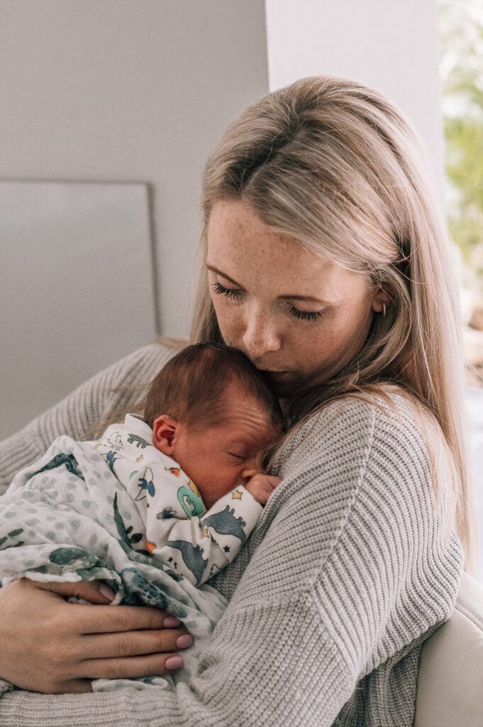 mother cuddling newborn baby