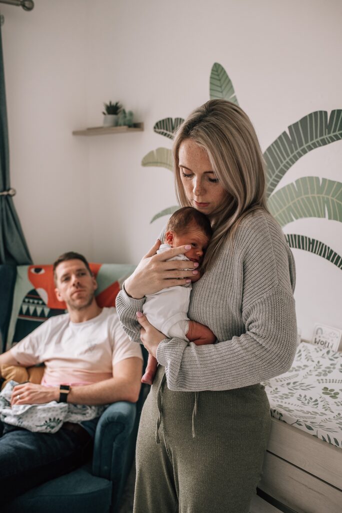 mother holding newborn baby in stylish nursery