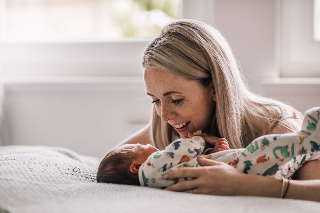 mother cradling newborn baby on a blanket