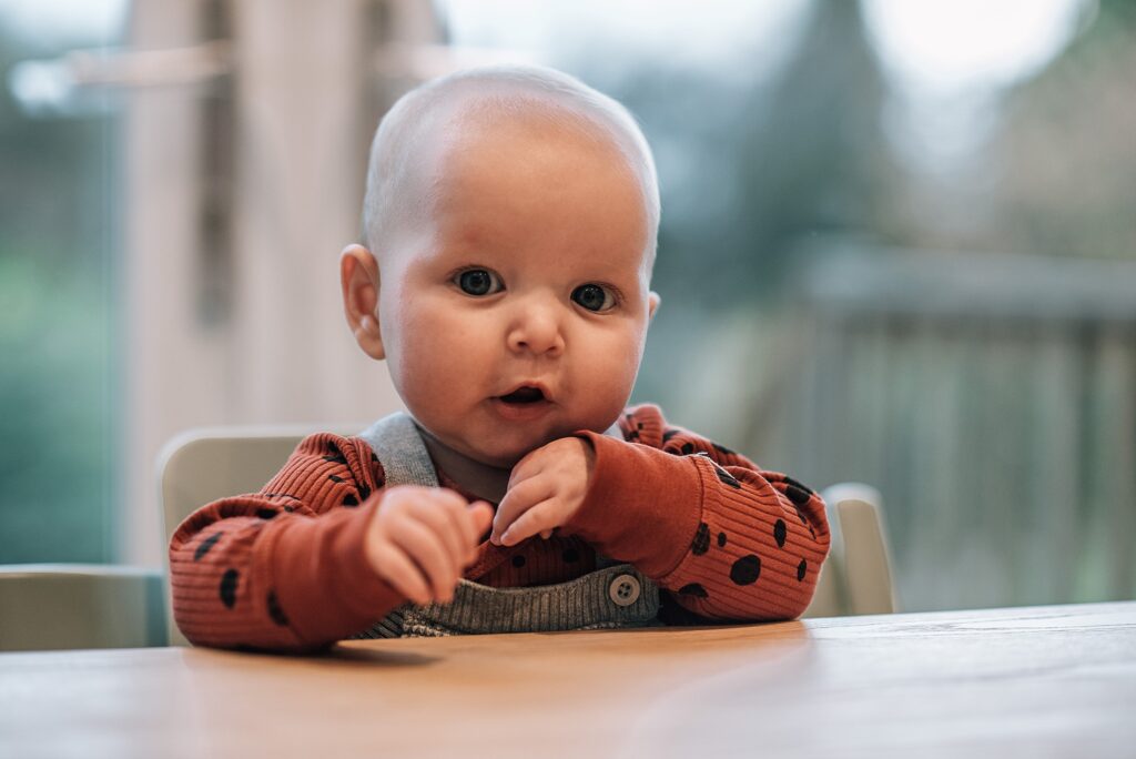 baby sitting up in a chair at a dining table
