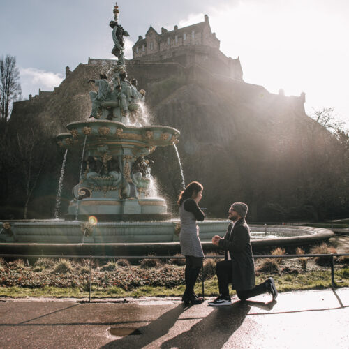 man down on one knee proposing to girlfriend in front of Ross Fountain, Edinburgh | proposal photography