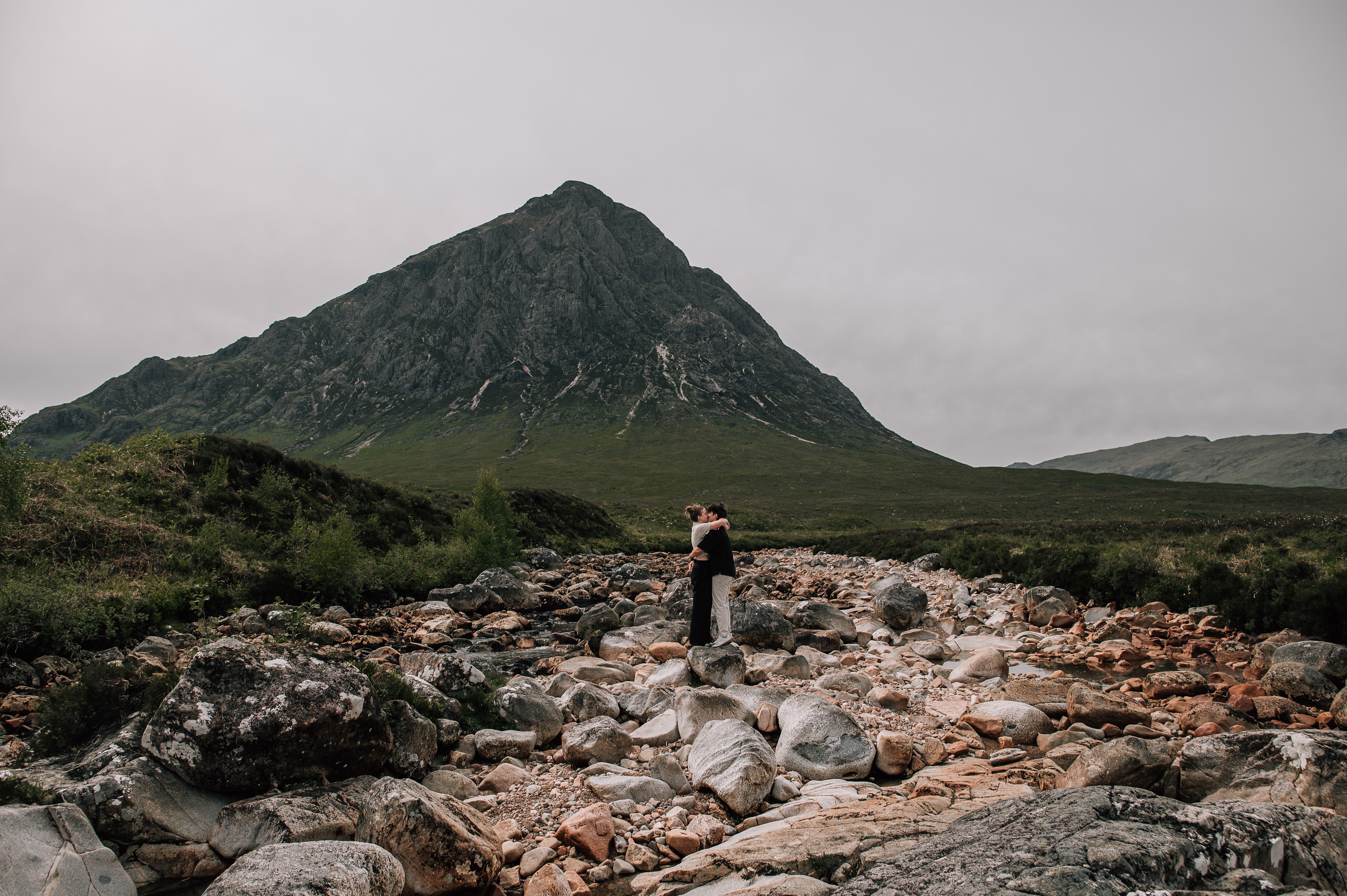 lgbtq couple kissing in front of a mountain Glencoe, Scotland
